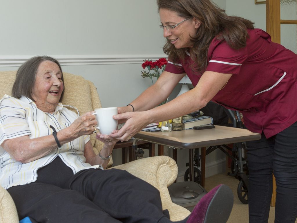 Carer serves a cup of tea to a client