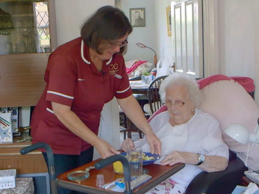 Home Care Assistant helps client with breakfast